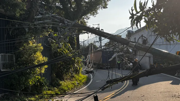 貨櫃車車身過高拉扯電線，導致電線桿東倒西歪，附近住戶停電中。翻攝畫面