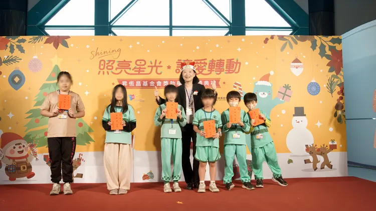 高雄國際航空站主任王郁珍（戴聖誕帽者）頒發獎助學金勉勵學童，場面溫馨。昇恒昌基金會提供