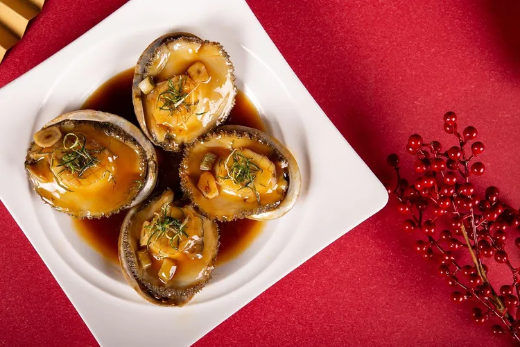 台北萬豪酒店2026年菜外帶，「崑崙南非鮑魚」選100公克肥美鮑魚，以清酒與昆布舒肥低溫慢煮六小時入味，再淋上金華火腿、老母雞、豬後腿肉精燉八小時的港式上湯，濃縮勾芡成特製紅燒醬，每份1988元。業者提供