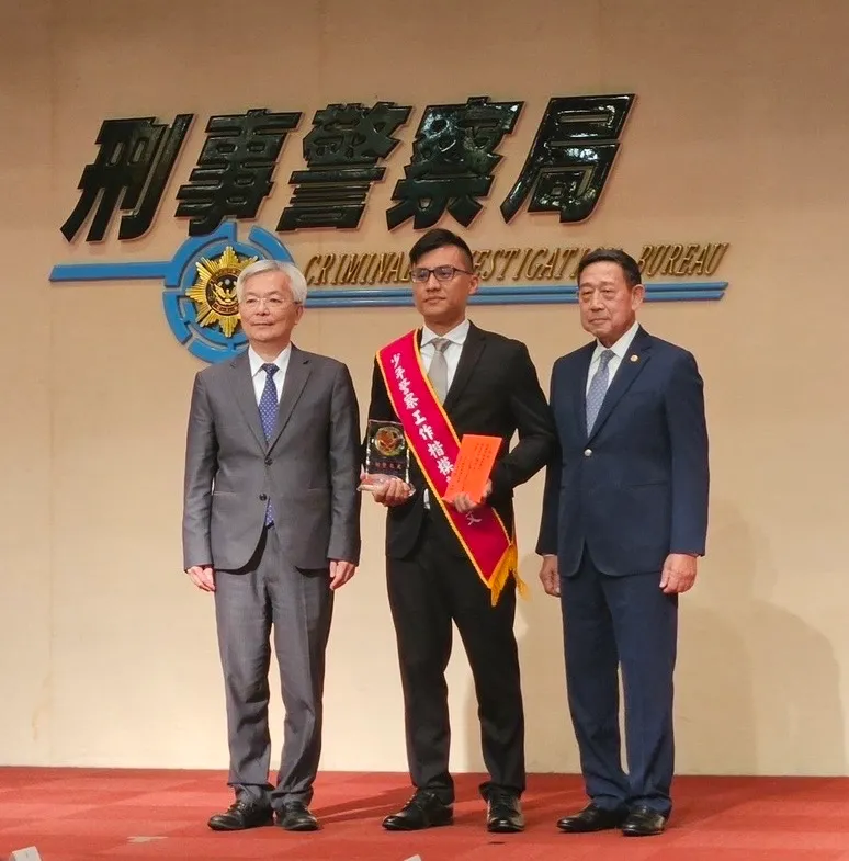 警政署长张荣兴与中华民国刑事侦防协会理事长黄炳彰联合颁奖给郭博文。翻摄画面