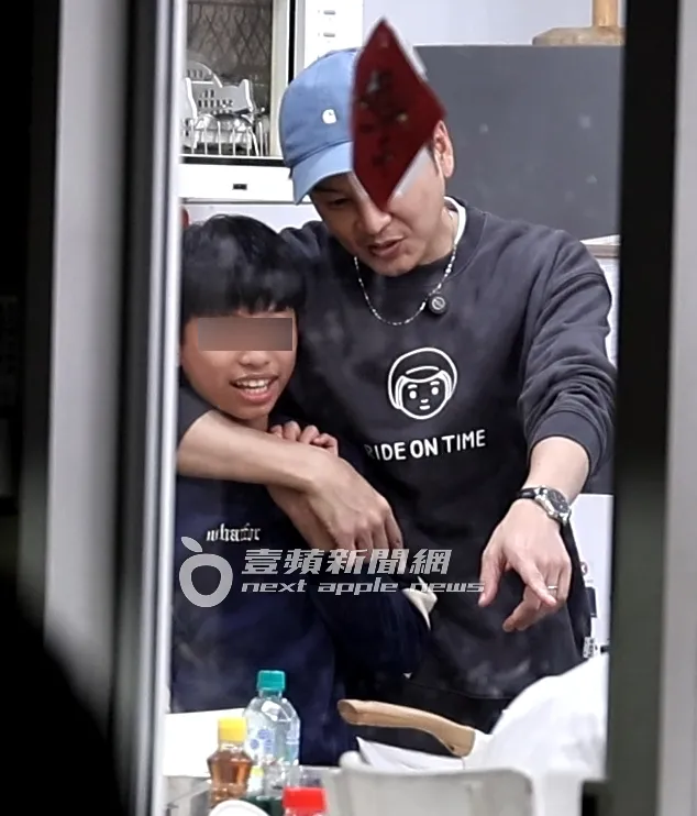 書偉單手勾著一名男童的肩膀，互動自然又親切。特勤中心攝