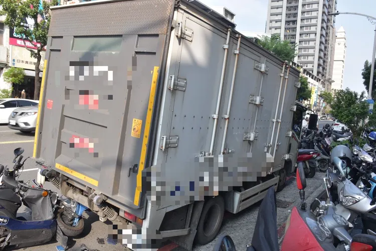張員連人帶車撞上違停卸貨的貨車，車頭毀損嚴重，零件散落一地。民眾提供