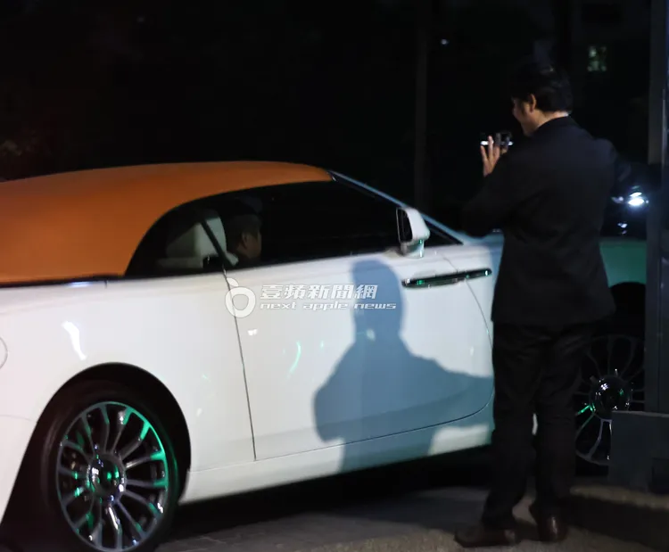 胡瓜坐上副駕返回信義區豪宅，物業保全認出胡瓜揮手致意。特勤中心攝