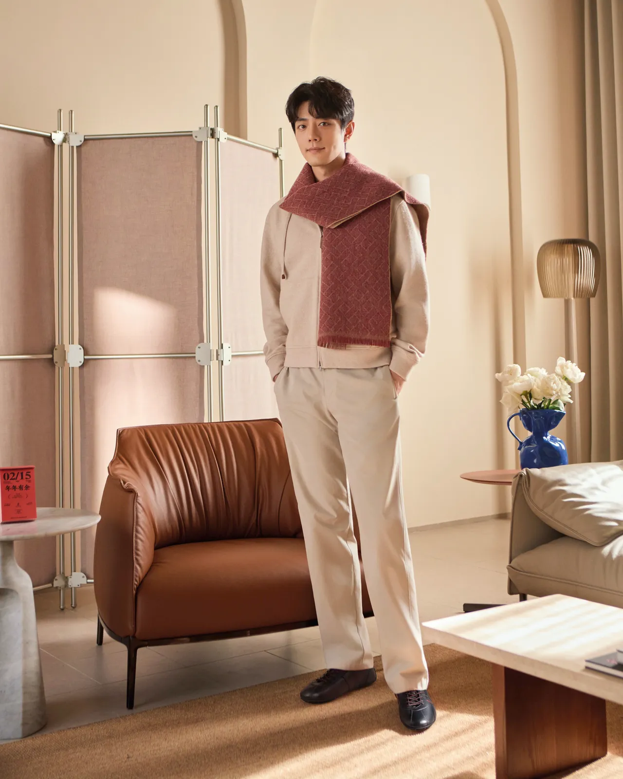 肖戰以一身俐落米白色造型搭配深紅色圍巾。品牌提供