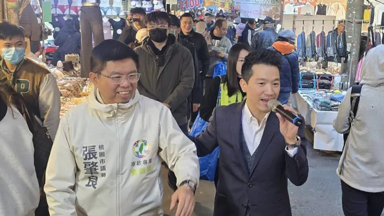 何志偉（右）今天前往桃園龍潭市場，陪爭取連任的市議員張肇良掃街。民眾提供