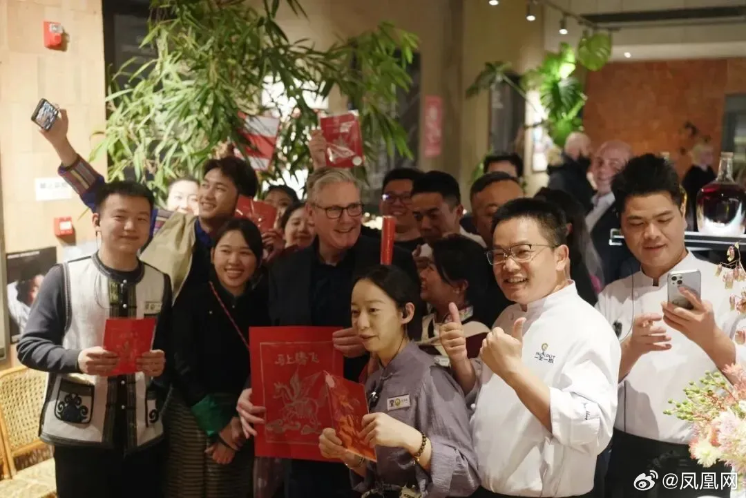 施凱爾在雲南菜餐廳與餐廳員工合影，並獲贈春聯。翻攝微博