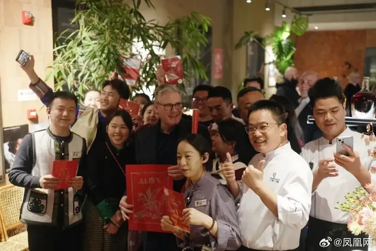 施凱爾在雲南菜餐廳與餐廳員工合影，並獲贈春聯。翻攝微博