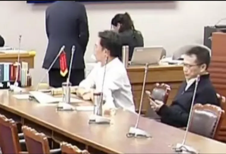 黃國昌將錦旗掛在桌前麥克風。翻攝自國會頻道