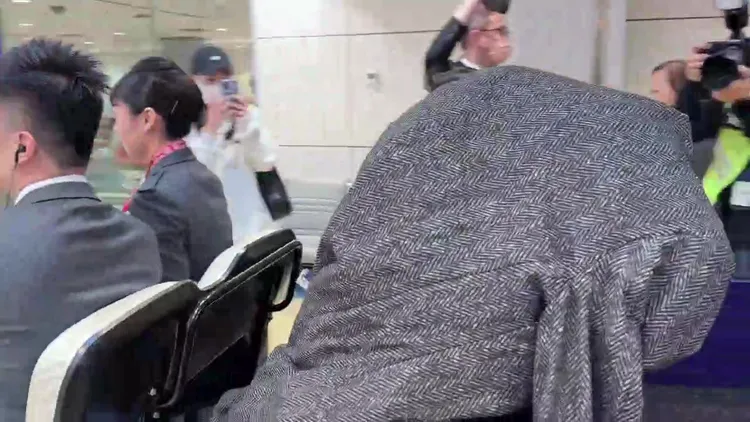 Jennie拿著灰色大衣蓋住頭，似乎不想被拍。桃園國際機場記者聯誼會提供