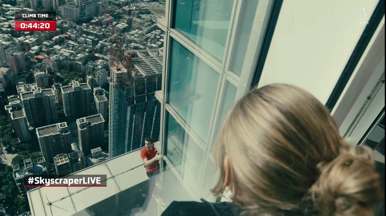 霍諾德的妻子桑妮特地靠近落地窗邊，以眼神與手勢為丈夫加油打氣。擷自Netflix