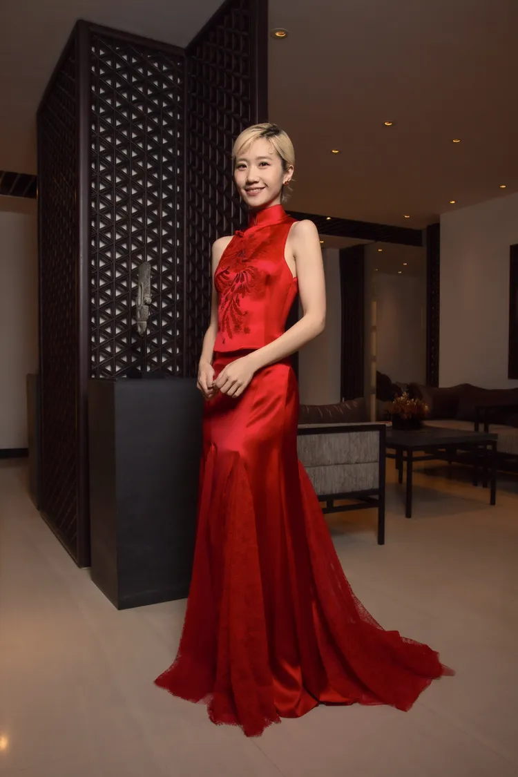 Lulu身著一襲夏姿紅中式立領削肩背心，搭配蕾絲絲緞拼接魚尾拖曳長裙。品牌提供