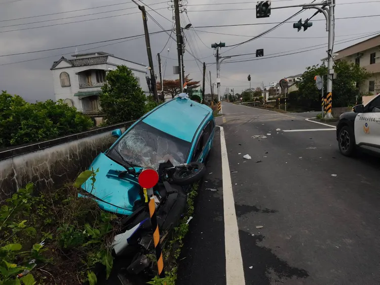 汽車與機車一起衝入路邊水溝中動彈不得。翻攝照片
