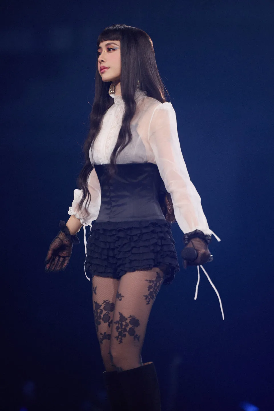 黑色斗篷脱下后以高领透肤雪纺衬衫搭配马甲式束身。凌时差提供