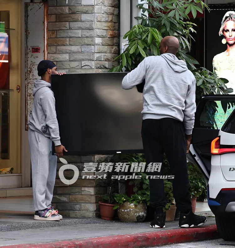 戴維斯和友人一起搬運電視。特勤中心攝