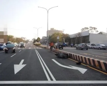 機車撞到鬼切轎車後，彈飛到分隔島。民眾提供