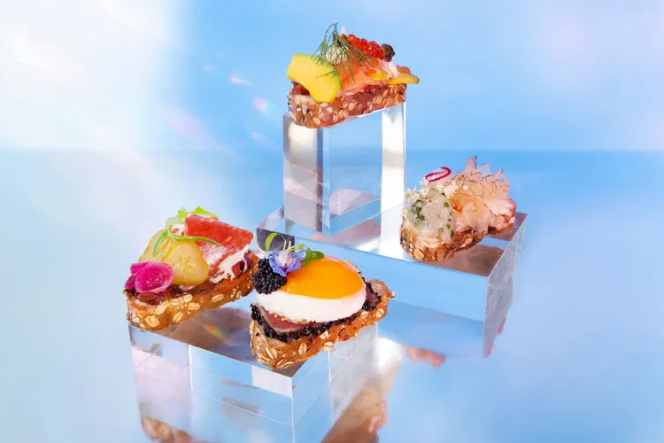 台北萬豪Lobby Lounge「極光夢遊下午茶」，四款精緻鹹點以北歐傳統主食裸麥麵包，搭配挪威煙燻鮭魚、鮭魚卵、干貝、伊比利風乾火腿、新鮮酪梨、銀耳、起士、鮪魚、半熟雞蛋及魚子醬等食材。業者提供