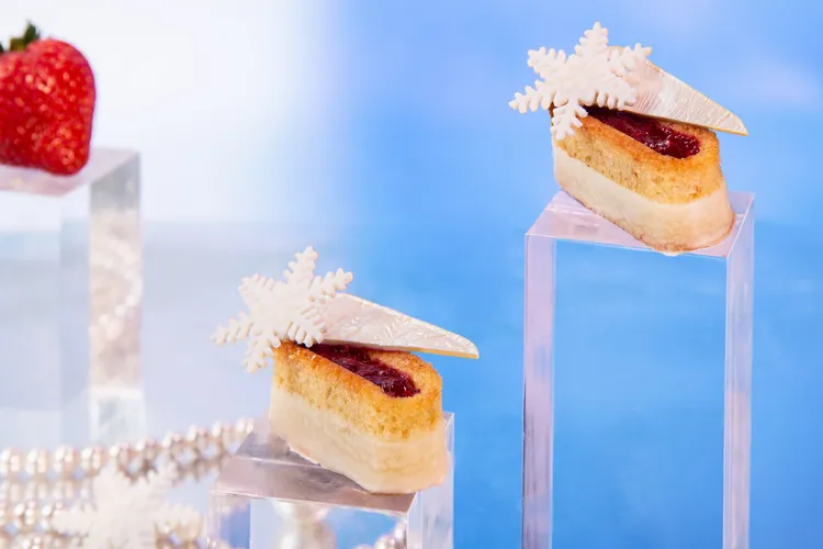 台北萬豪Lobby Lounge「極光夢遊下午茶」，　「芬蘭魯內貝里蛋糕」為芬蘭的節慶限定糕點。特色以濕潤蛋糕體混合杏仁與蘭姆酒香氣，再填入覆盆子果醬，以法芙娜白巧克力及雪花巧克力妝點。業者提供