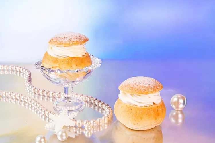 台北萬豪Lobby Lounge「極光夢遊下午茶」，「瑞典薩姆拉奶油餐包」看似像泡芙實則以小麥、小荳蔻粉、杏仁粉、糖和牛奶烤製成細緻柔軟的圓形甜麵包，夾入滑順日本中澤鮮奶油餡、輕撒糖粉。業者提供