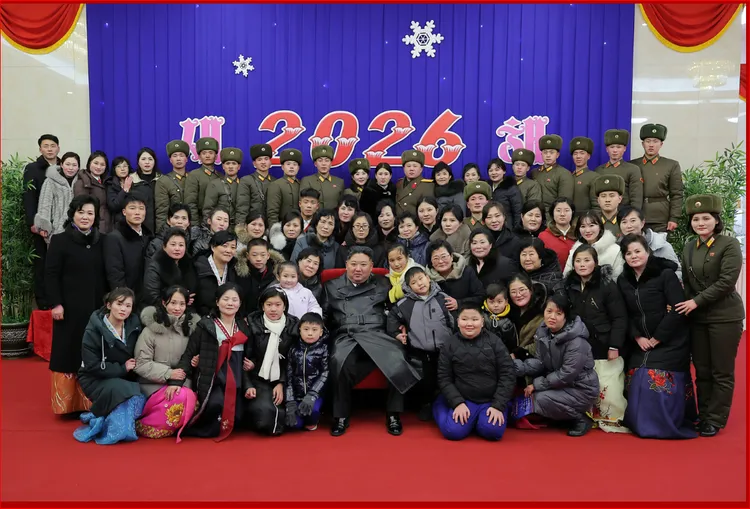 金正恩和海外作戰士兵的家屬們合照。勞動新聞