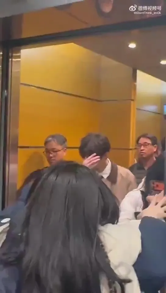 由於電梯裡有一般乘客，成訓面露尷尬搔頭。翻攝微博