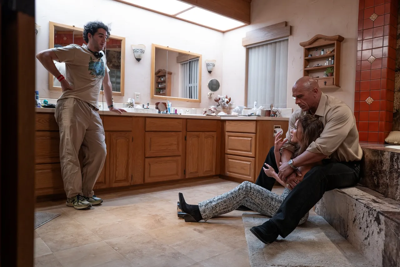 導演班尼沙夫戴（左）在拍攝現場與巨石強森（右後）跟艾蜜莉布朗（右前）討論演出方式。采昌提供