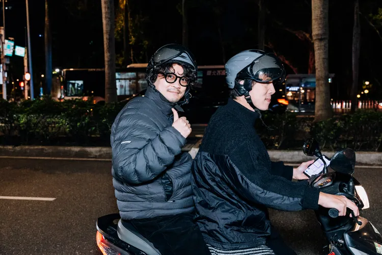 鈴木龍也（左）不畏寒流，入境隨俗體驗坐機車，被翻譯載著逛台北街頭。佳映娛樂提供