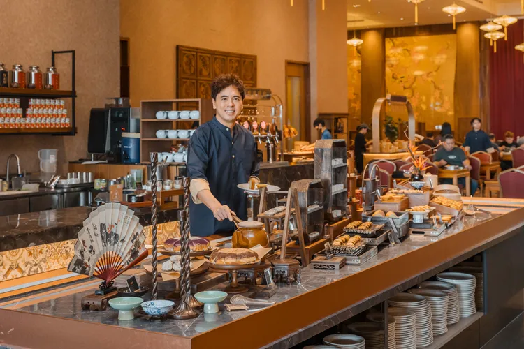 路易莎董事長黃銘賢與隱岳閣餐檯合照。路易莎提供