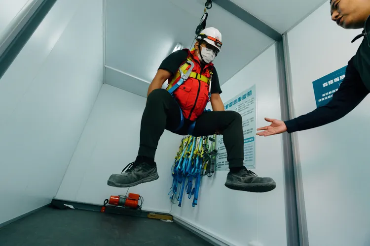 安全危害模擬訓練中心導入體感訓練，加深安全意識教育，圖為安全帶吊掛時，引導學員實施正確防護動作。台積電提供