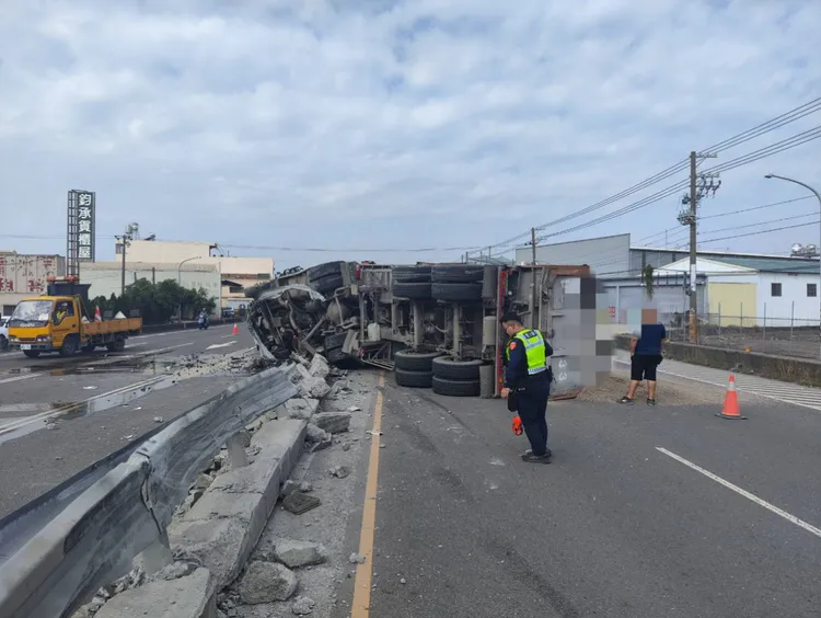 砂石車翻覆後載運的土石灑落一地，占據車道影響通行。民眾提供