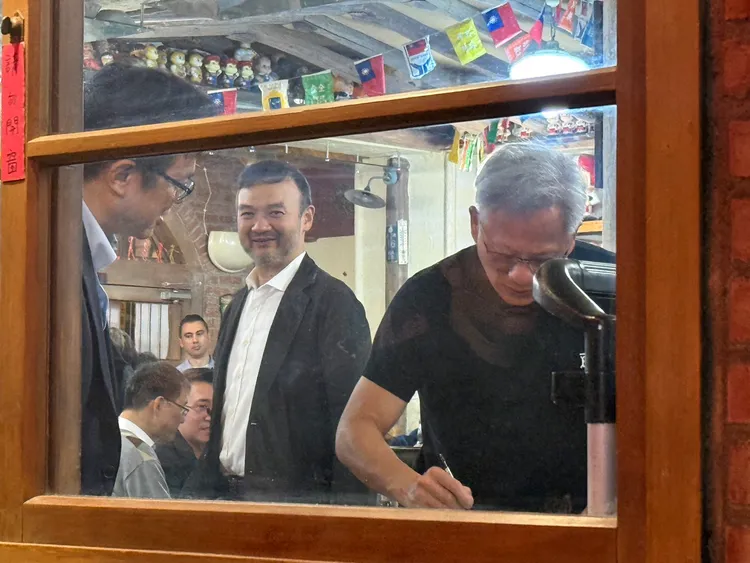 智邦總經理李訓德（左）拿出AI伺服器基板讓輝達執行長黃仁勳（右）簽名。呂承哲攝