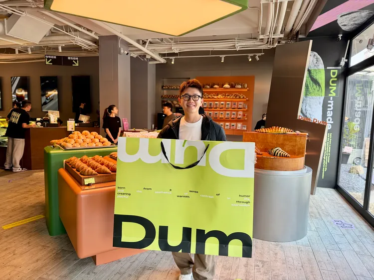 尊鴻餐飲集團執行長陳詠翔，秀出店內超大尺寸的麵包提袋。莊偉祺攝