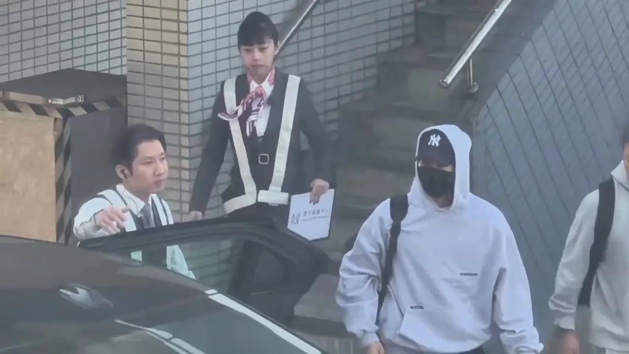 宋仲基（右）戴上帽T的帽子，准备上车。桃园国际机场记者联谊会提供