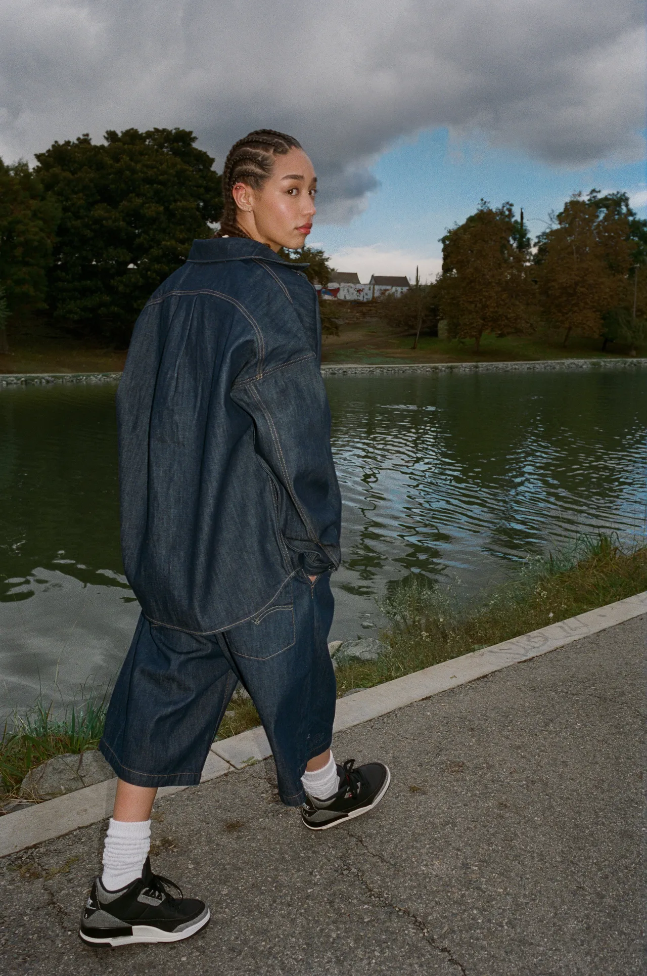 寬鬆丹寧短褲以 12 盎司水洗靛藍丹寧製成，寬鬆剪裁結合深褶結構，褲長落於膝下更顯隨性。品牌提供