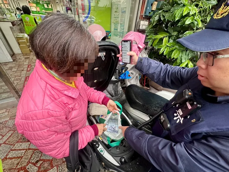 警員協助婦人取出機車座墊下的140萬元現金。龍潭警分局提供