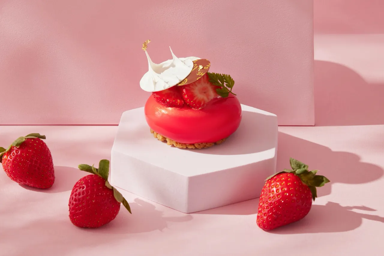 台北喜來登大飯店草莓系列甜點「草莓白乳酪蛋糕」選用依思尼白乳酪，以白乳酪慕斯覆蓋蜂蜜海綿蛋糕與草莓庫利，底部鋪上酥脆康布酥，清爽不膩。台北喜來登大飯店提供