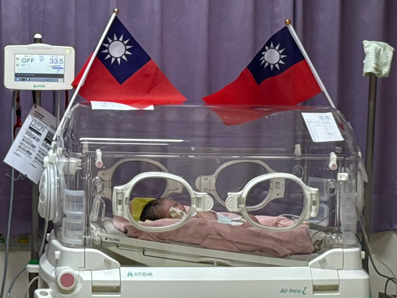 台中医院妇产科婴儿室内喜迎元旦宝宝报到，婴儿床旁插上小国旗，喜气洋洋。台中医院提供