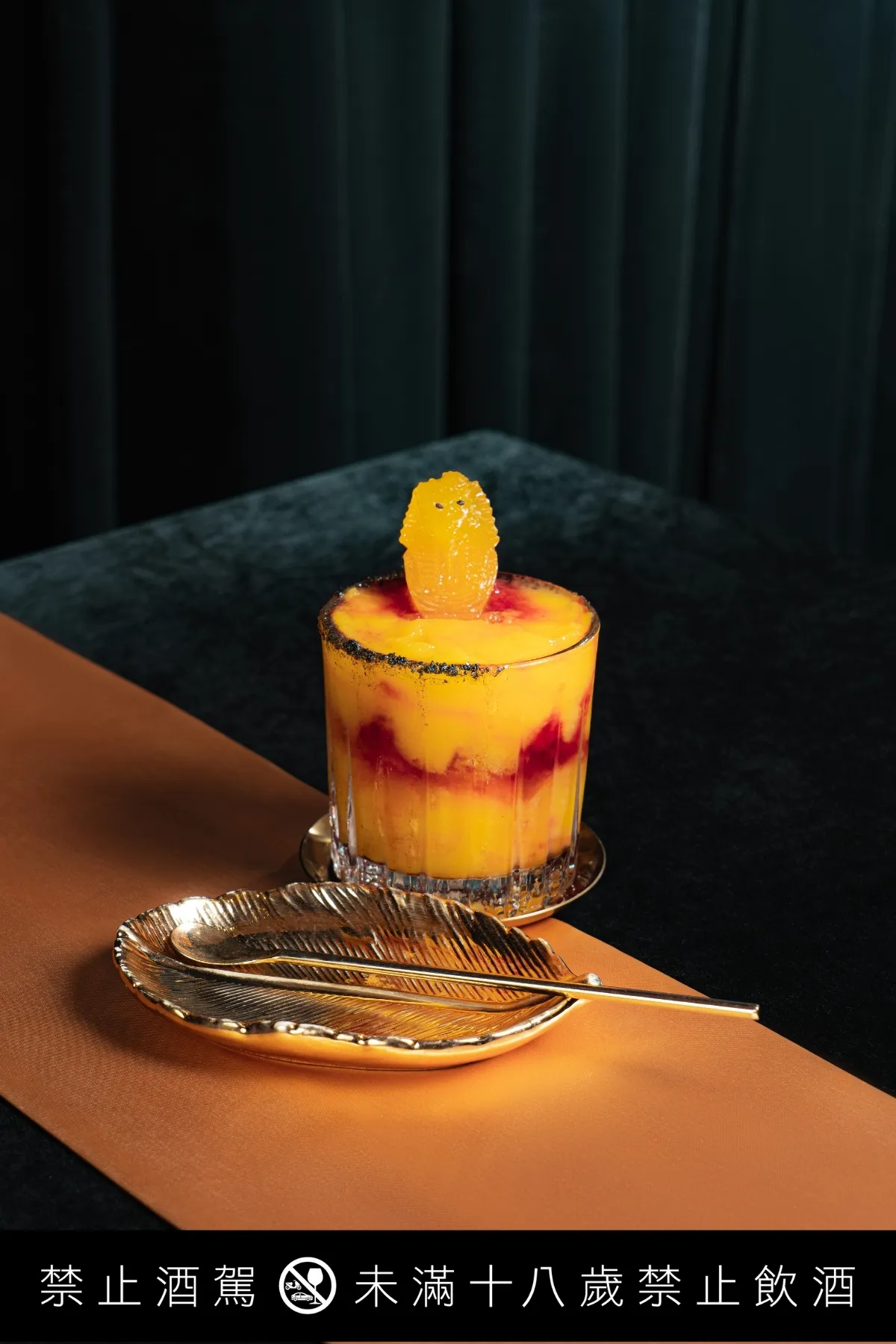 「日落埃及花果調酒」以木槿花與芒果為靈感，法老造型冰塊隨融化呈現層次色澤。金色三麥提供