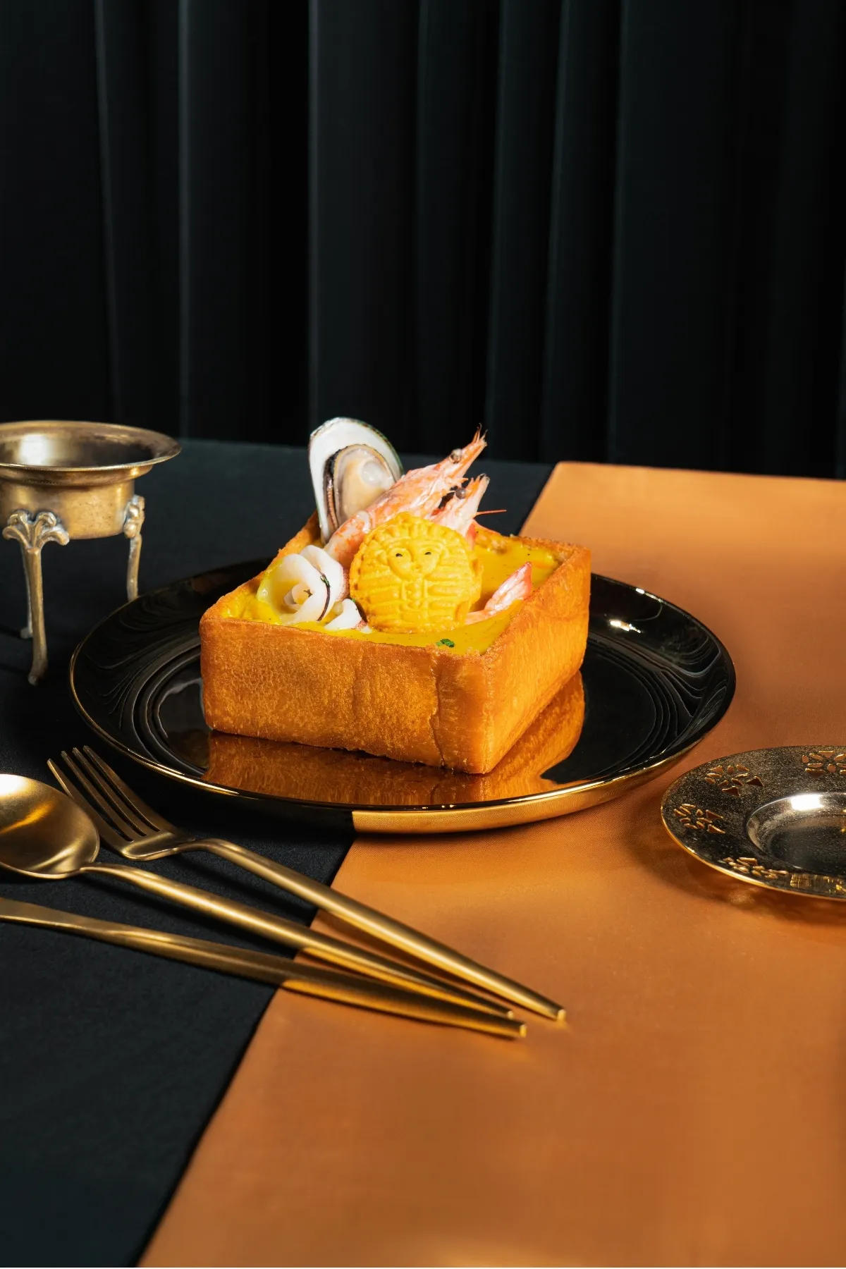 「法老王海鮮棺材板」結合台南經典小吃與埃及意象，厚切吐司盛裝香料海鮮濃湯，視覺吸睛。金色三麥提供