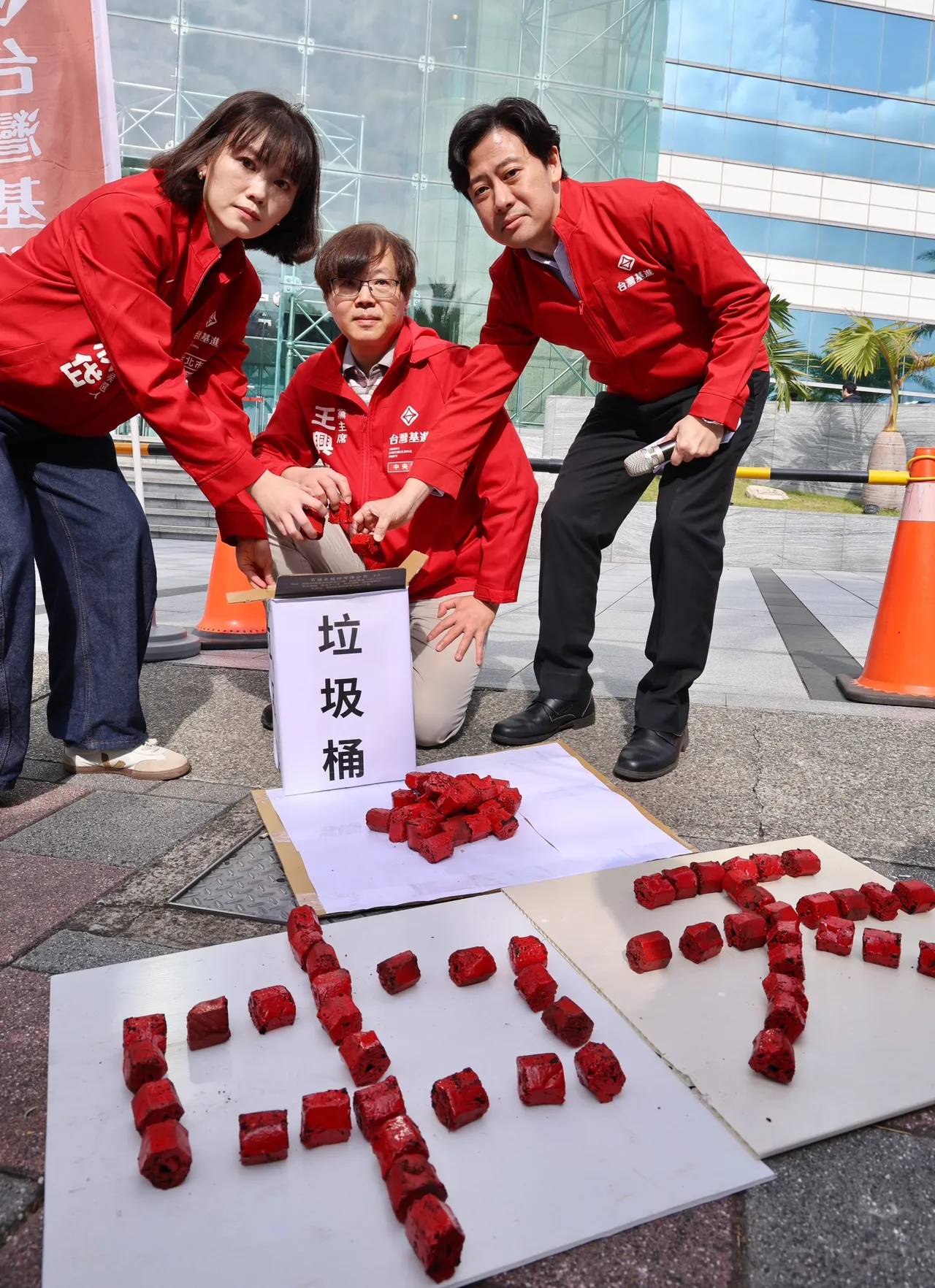 台灣基進把象徵「紅媒」的紅色煤炭，扔進垃圾桶。莊宗達攝