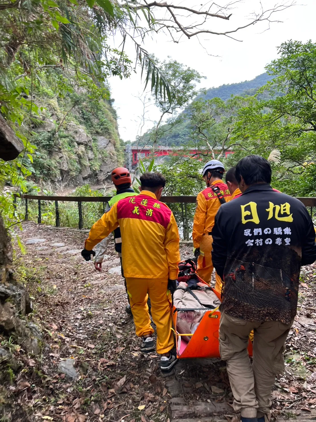 救難人員以人力接駁運送方式將葉男抬至步道入口。消防局提供