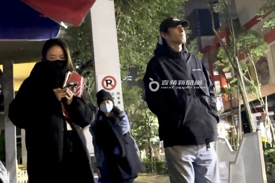 黃騰浩（右）戴著帽子，雙手插口袋，看著懷秋和陳孟琪被警察臨檢。特勤中心攝