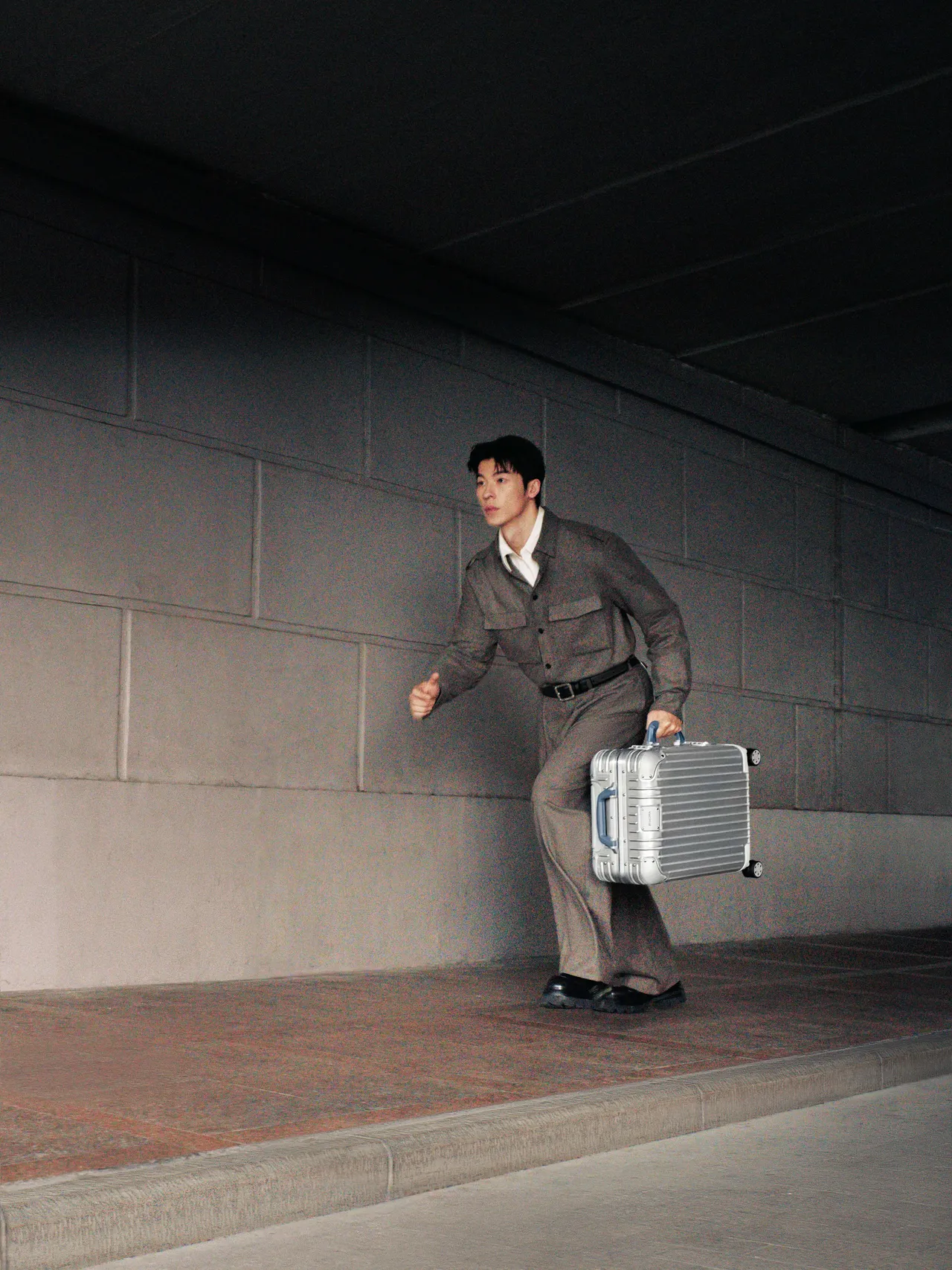 许光汉拎起RIMOWA全新Original柔雾蓝行李箱在城市中移动。品牌提供