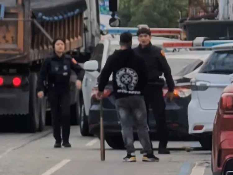 男子手持長刀及棍棒與警對峙。翻攝threads@dj.ranbo