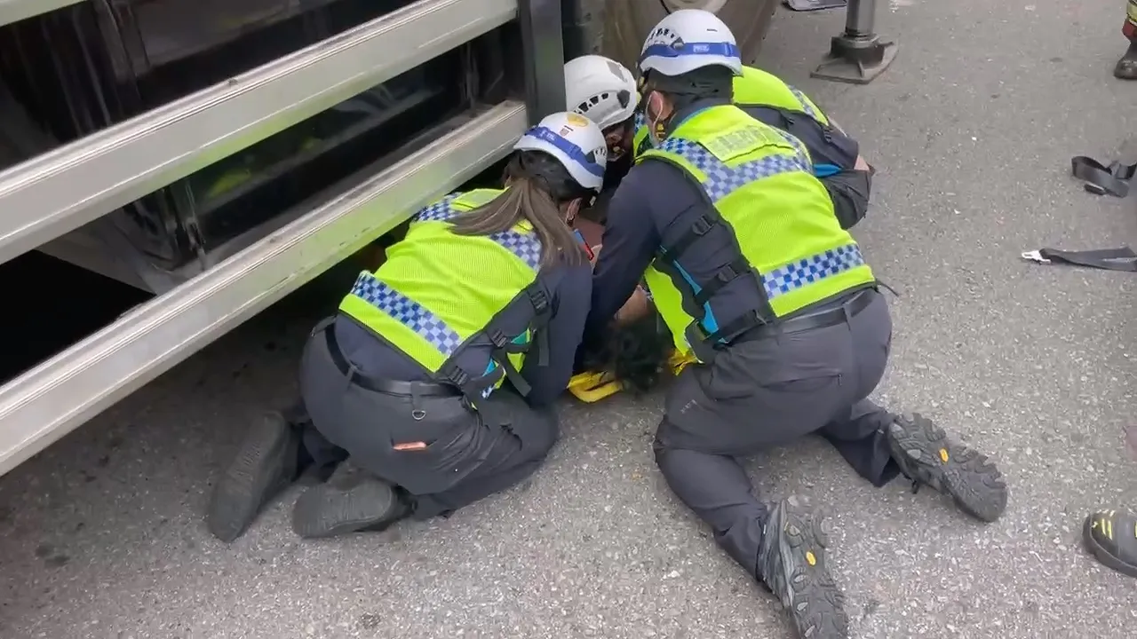 消防人員搶救受困車底的劉姓男子。民眾提供