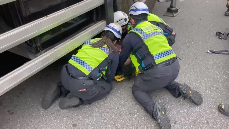 消防人員搶救受困車底的劉姓男子。民眾提供