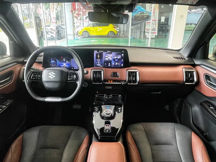 e Vitara車艙以黑色與棕色內裝配色營造沉穩質感，10.25吋數位儀表與10.1吋中控螢幕整合為一體式介面，科技氛圍與實用機能兼具。林浩昇攝