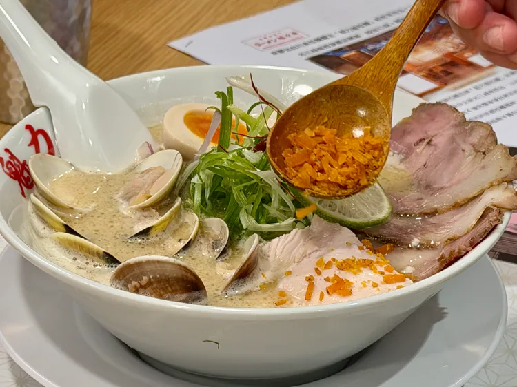 「金燦烏魚子雞白湯貝拉麵」上桌時由工作人員撒上現烤烏魚子。莊偉祺攝