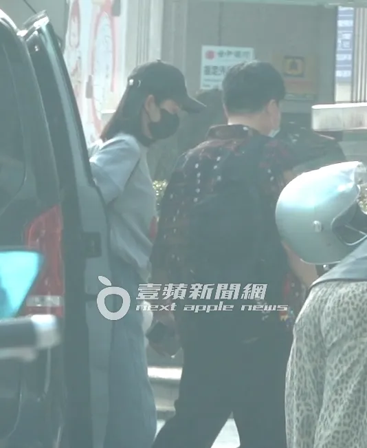 林依晨（左）戴黑色棒球帽和口罩在汐止表演工作坊下車，繼續彩排工作。特勤中心攝