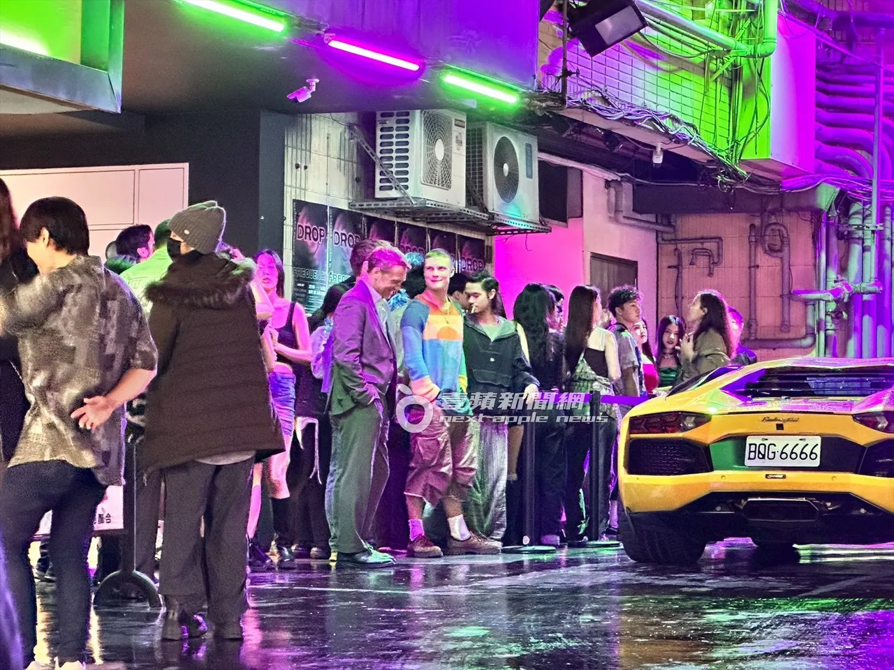 山姆沃辛頓手插口袋排隊，一邊和路人聊天。特勤中心攝