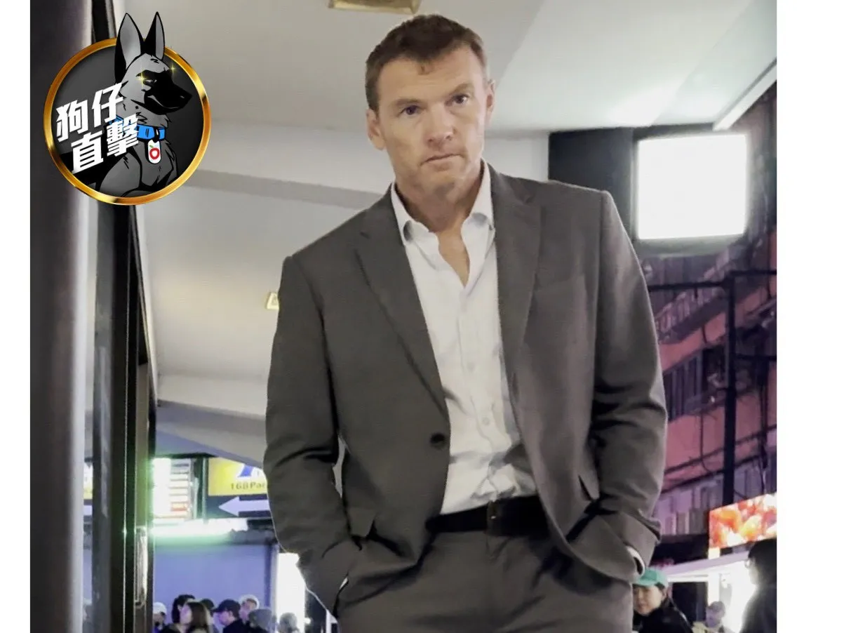 山姆沃辛頓整套灰色西裝、腳踩皮鞋，現身東區茶街。特勤中心攝